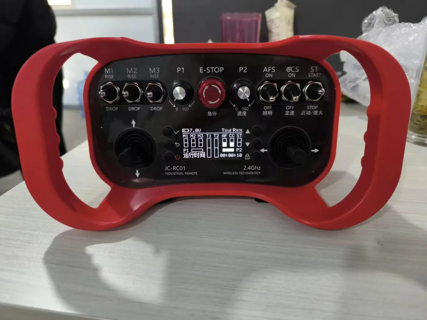 Handheld industrial remote-control unit with dual joysticks and emergency stop