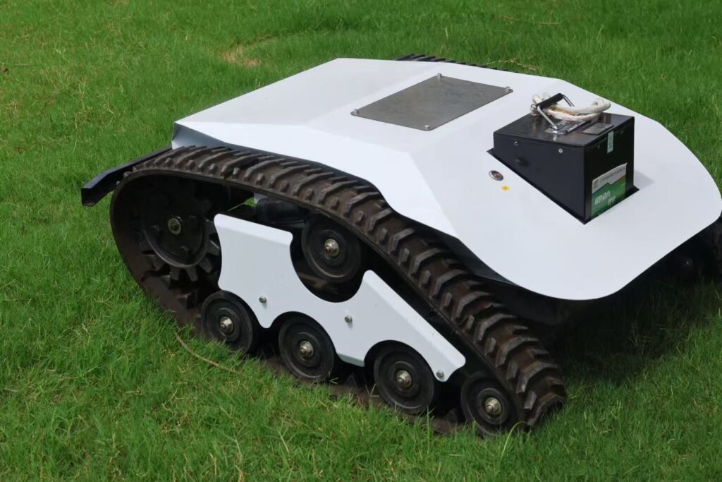 Close-up of heavy-duty rubber tracks and chassis on remote control crawler lawn mower
