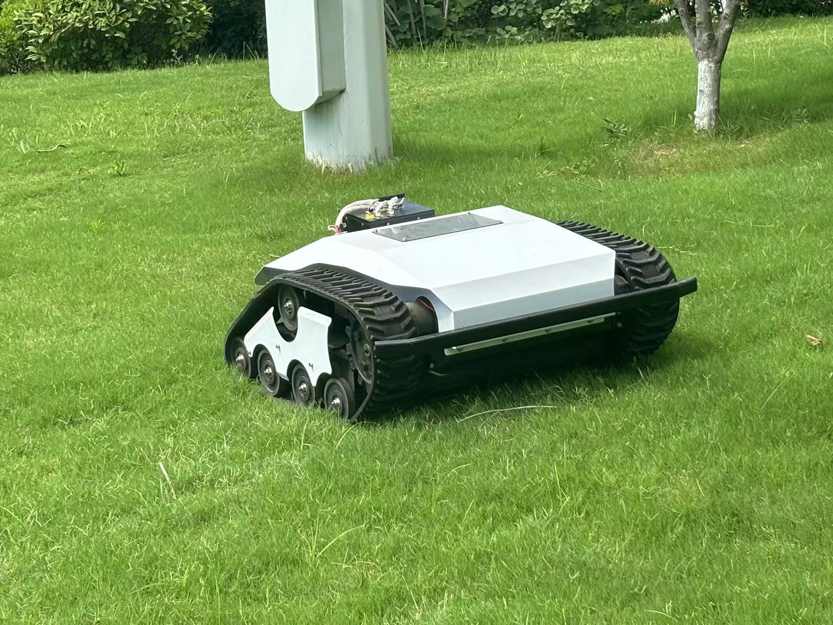 commercial tracked self propelled electric lawn mower operating on turf